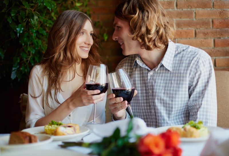 Portrait of amorous young couple toasting with red wine